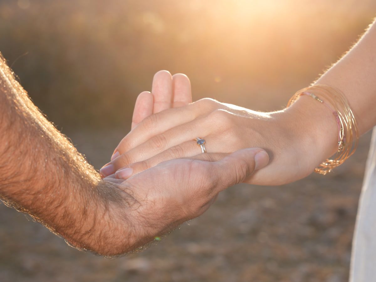 Engagement ring in golden-hour light as the couple hold hands in Agafay, Marrakech