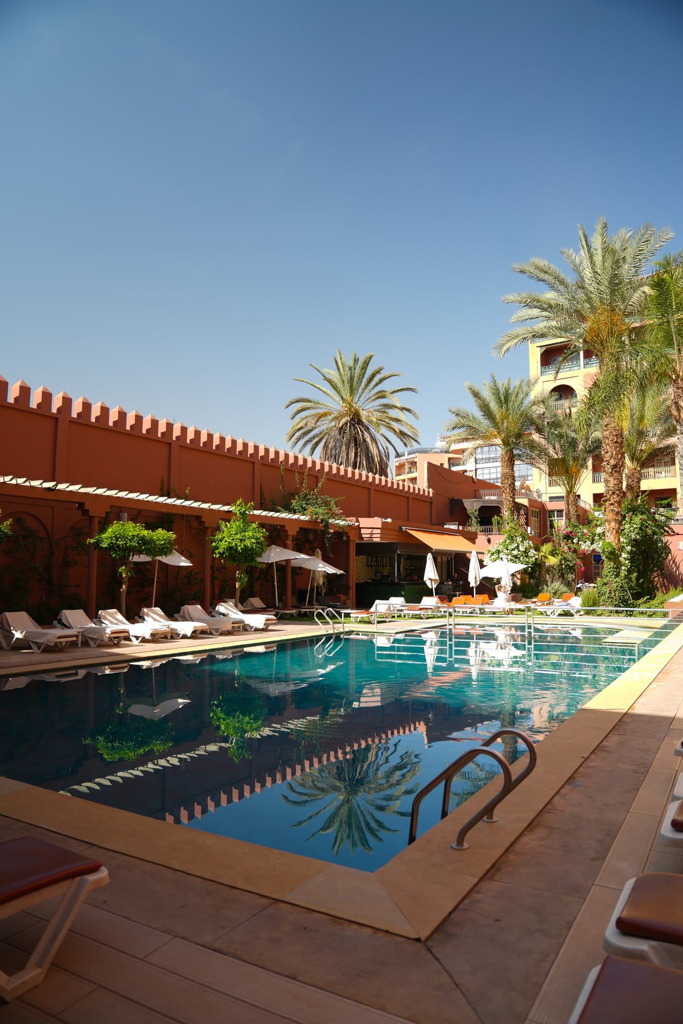 Hotel pool lined with palm trees in Marrakech