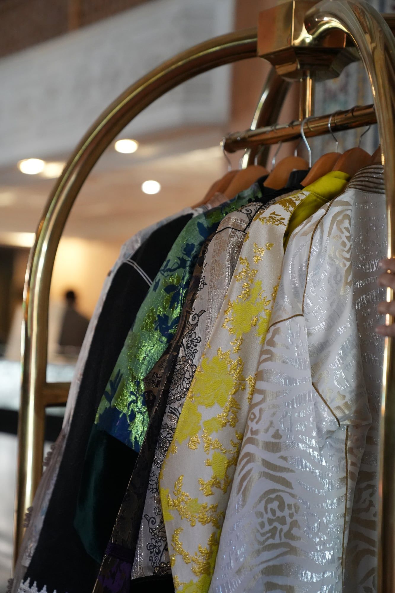Kaftan collection hanging on a brass hotel rail