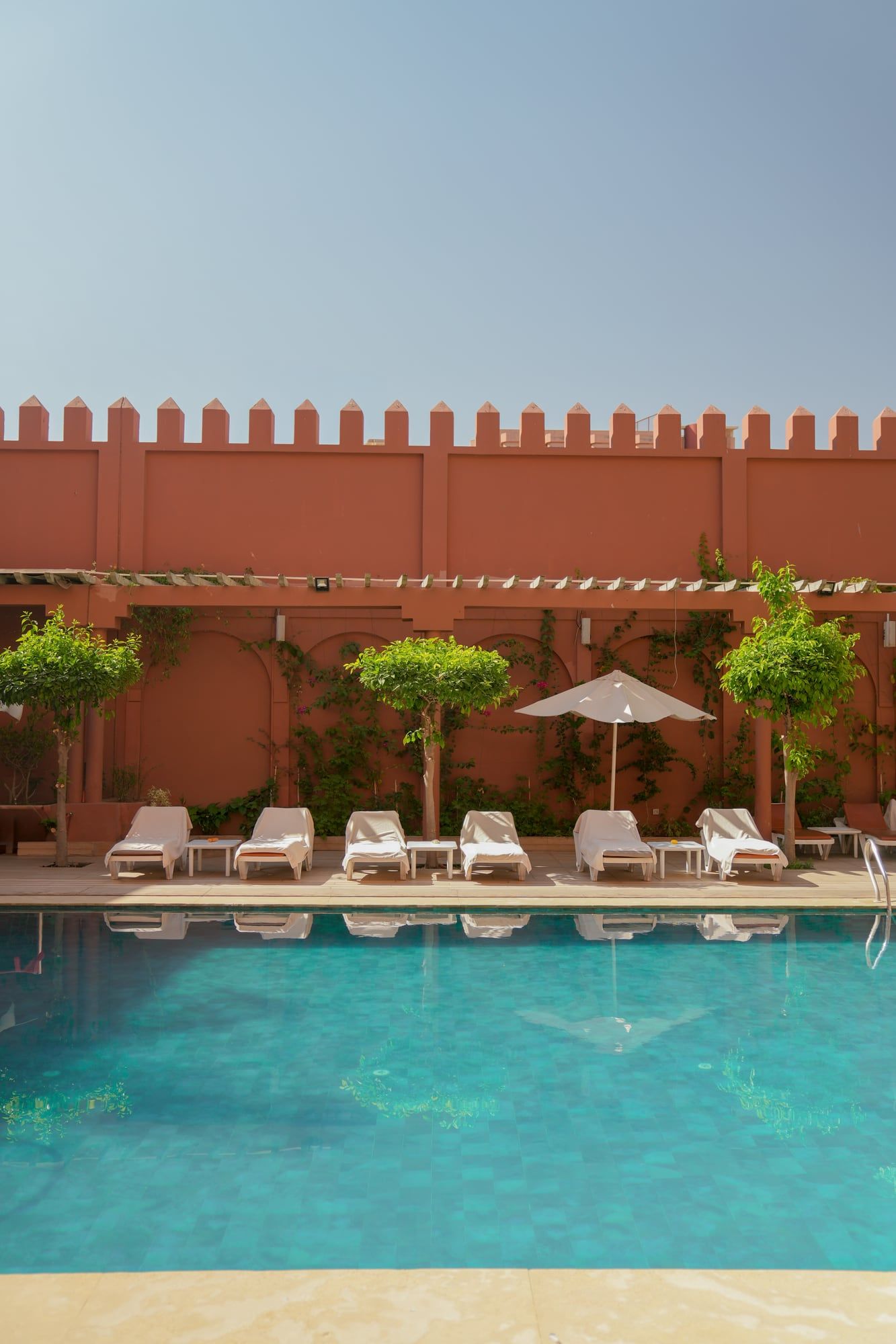 Pool terrace below ochre crenellated walls