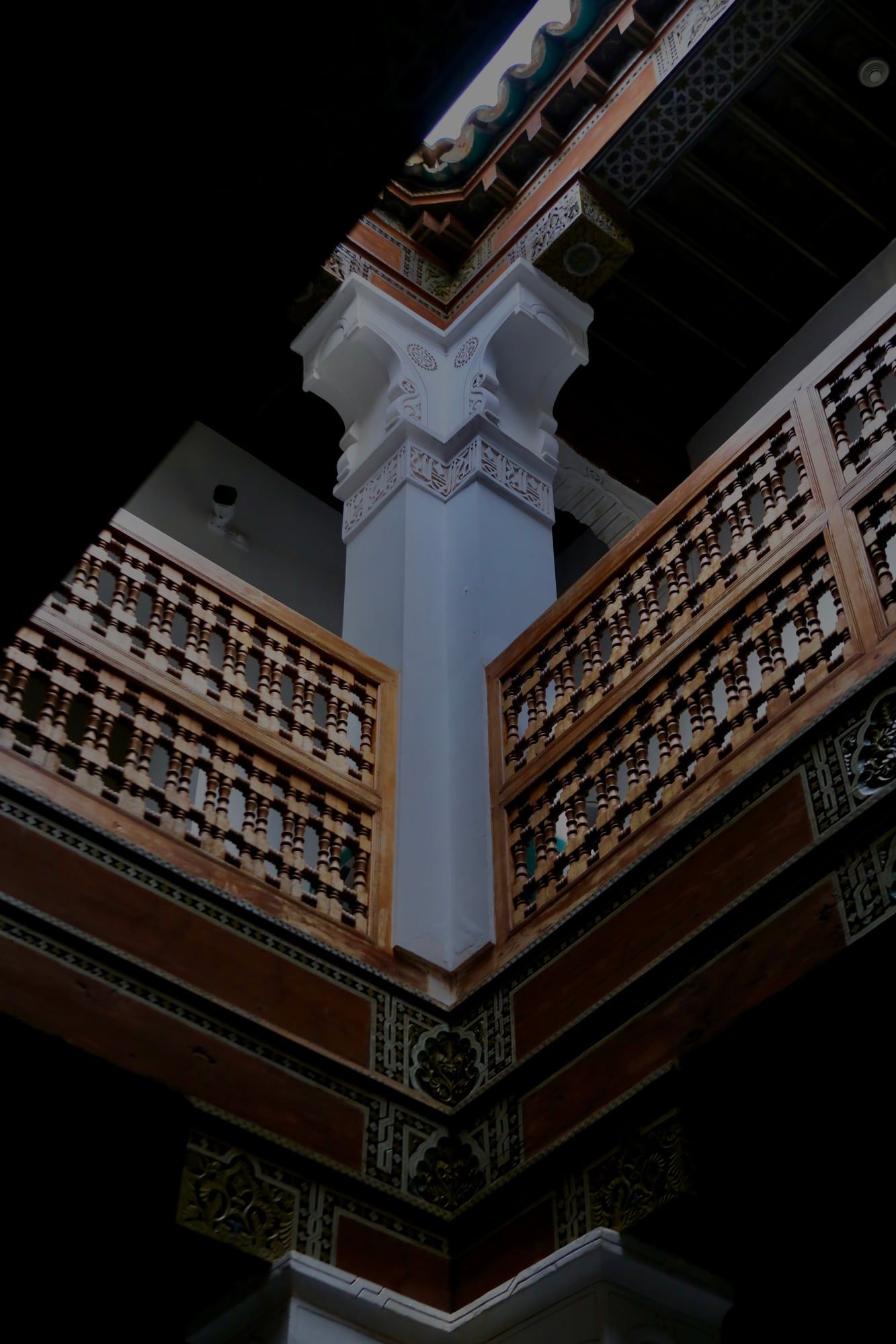 Carved wooden galleries of a riad atrium seen from below