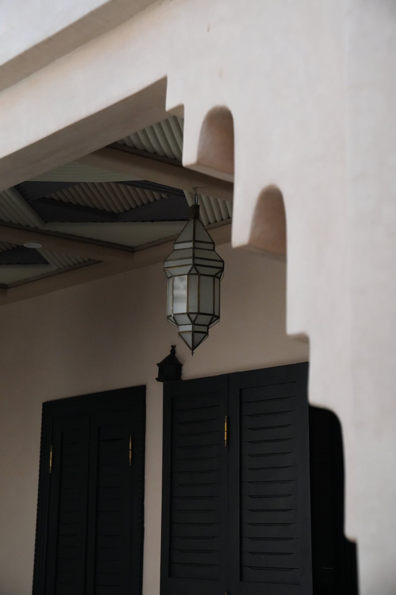 Whitewashed entrance with a wrought-iron lantern